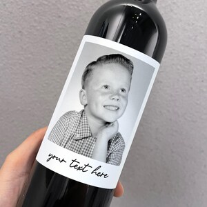 May include: A black and white photo of a young boy with a checkered shirt is on a wine bottle label. The label has the text "your text here" on it.