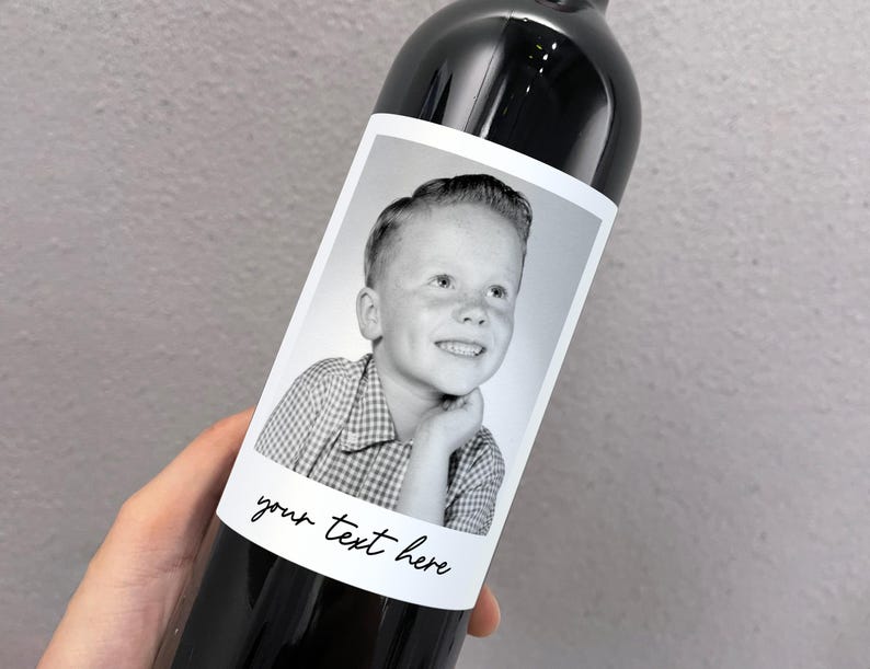 May include: A black and white photo of a young boy with a checkered shirt is on a wine bottle label. The label has the text "your text here" written on it.