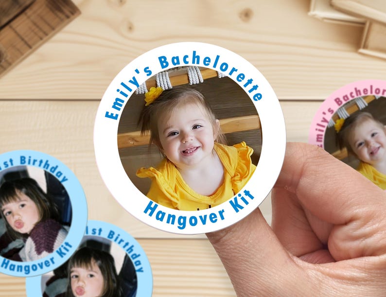 Op de afbeelding: Een ronde witte sticker met blauwe tekst die "Emily's Bachelorette Hangover Kit" zegt en een foto van een jong meisje met blond haar dat een geel shirt draagt.