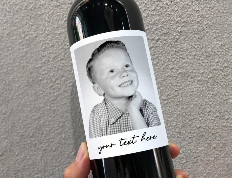 May include: A black and white photo of a young boy with a checkered shirt is on a wine bottle label. The label has the text "your text here" printed on it.