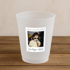 May include: A frosted plastic cup with a photo label. The label reads "Riley's 30th Birthday" above a vintage photo of a child wearing sunglasses and holding a microphone. The text "Vintage 1995" is below the photo.