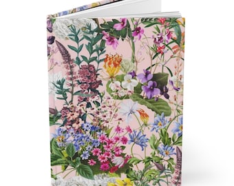 May include: A pink journal with a floral pattern featuring a variety of colorful flowers, including purple, pink, blue, yellow, and white.