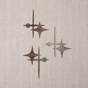 Può includere: Tre forme a stella a raggiera in legno con bordi arrotondati e un motivo a venature del legno marrone. Le stelle sono disposte a scalare.