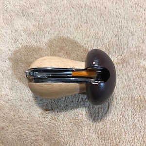 May include: A wooden pipe with a dark brown bowl and a light brown stem. The pipe has a metal component and a small opening in the bowl. The pipe is designed for smoking.