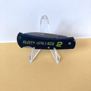 May include: Black pocket knife with a yellow inscription that reads "Rusty Wallace 2".