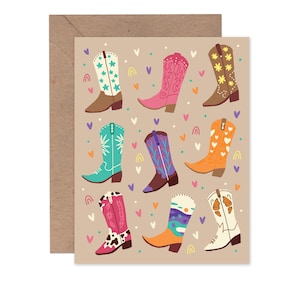 May include: A greeting card featuring a collection of colorful cowboy boots in various designs. The boots are decorated with stars, flowers, and other patterns, set against a tan background with hearts and rainbows. The card is paired with a brown envelope.