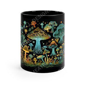 May include: Black ceramic mug with a colorful illustration of mushrooms and foliage. The mushrooms are in shades of yellow, orange, and blue, and the foliage is green. The background is black.