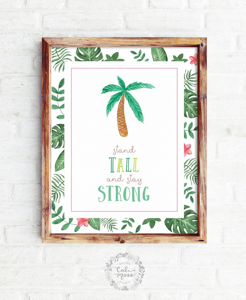 May include: A framed print with a watercolor illustration of a palm tree and the text "stand tall and stay strong". The frame has a green and pink tropical leaf border.