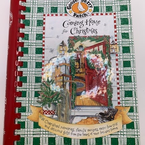 May include: A green and white checkered cookbook with a red spine. The cover features a goose illustration and the text "Gooseberry Patch" and "Coming Home for Christmas". The text "Cherished memories, family recipes, easy how-to's and delicious gifts from the heart of your holiday home" is also on the cover.