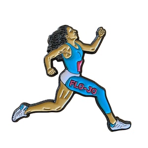 May include: A gold-colored enamel pin depicting a female runner in a blue and white uniform with the text "FLO-JO" on her leg. The runner is in mid-stride with her right leg extended and her left arm raised.