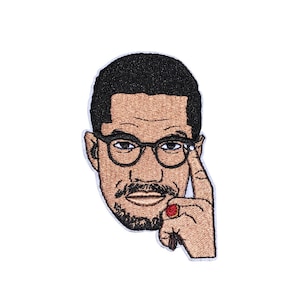May include: Embroidered patch featuring a portrait of a man with black hair, brown skin, and glasses. He is wearing a red ring on his finger and has a thoughtful expression.