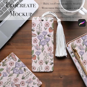 Puede incluir: Una maqueta de Procreate con un diseño floral con mariposas, abejas y fresas. El diseño está en un marcapáginas, un cuaderno y un diario. El marcapáginas tiene una borla blanca. El texto dice: "Procreate Mockup".