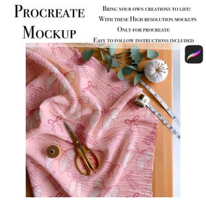 May include: Pink fabric with a white bow pattern. The fabric is folded and lying on a wooden surface. There are sewing supplies around the fabric, including a spool of thread, a measuring tape, and a pincushion.