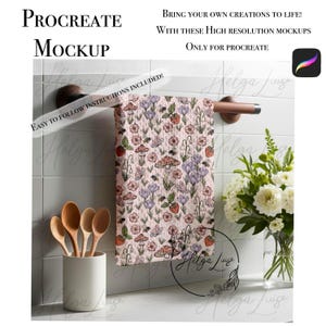 Puede incluir: Una maqueta de una toalla de cocina con un patrón floral que presenta fresas, champiñones, mariposas y flores sobre un fondo rosa. La toalla está colgada en un toallero en un baño. El texto "EASY TO FOLLOW INSTRUCTIONS INCLUDED!" es visible en la imagen.