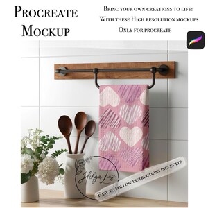 Puede incluir: Una toalla rosa y blanca con estampado de corazones cuelga de una barra de madera con detalles metálicos negros. Las palabras "Procreate Mockup" están en la parte superior izquierda. El texto "Bring your own creations to life!" también es visible.