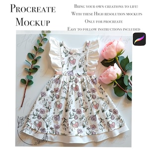 Puede incluir: Un vestido blanco con un estampado floral con flores rosas, llaves y corazones. El vestido tiene un ribete de volantes blancos alrededor del escote y una cinta rosa alrededor de la cintura. El vestido está colocado plano sobre una superficie blanca con follaje verde y rosas rosas.