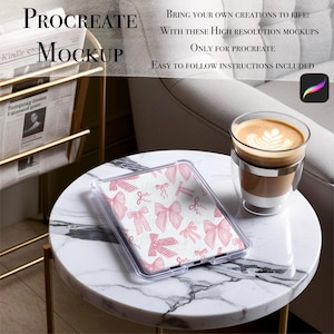 Puede incluir: Una funda transparente para tableta con un diseño de lazo rosa descansa sobre una mesa con tapa de mármol. El texto "Procreate Mockup" es visible. Una taza de café con arte latte está cerca. También se ve el texto "Bring your own creations to life!"