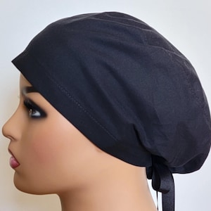 May include: A black scrub hat with a tie at the back. The hat is made of a soft, comfortable fabric.