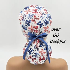 May include: A white scrub cap with a pattern of red and blue bows and stars. The cap is tied with a blue ribbon. Text on the right says "over 60 designs".