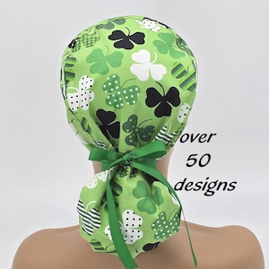May include: Green surgical scrub hat with a pattern of black and white four-leaf clovers. The hat has a green ribbon tie.  Over 50 designs.