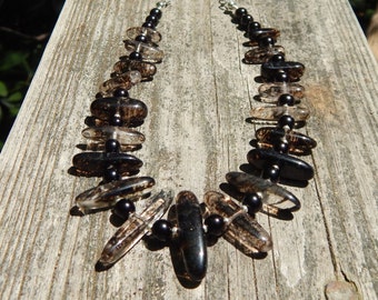 Glass quartz necklace in shades of brown, speckled and clear glass beads, with black crystal pearls, and silvertone chain.
