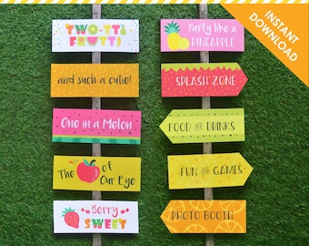 May include: Printable party signage with a fruit theme. The signs feature phrases like "Two-tti Frutti", "Party like a Pineapple", "Splash Zone", "One in a Melon", "Food and Drinks", "Fun and Games", "The Apple of Our Eye", "Berry Sweet", and "Photo Booth".