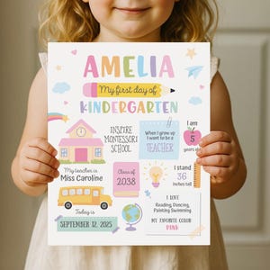 以下が含まれることがあります： 上部に「AMELIA」という名前が入った、カラフルな幼稚園の看板。「My first day of KINDERGARTEN」というテキスト、スクールバス、日付「SEPTEMBER 12, 2025」が含まれています。「身長91cm」とも記載されています。