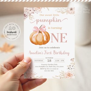 Op de afbeelding: Een verjaardagsuitnodiging met een aquarel pompoen en een roze strik. De tekst luidt "Our sweet little pumpkin is turning ONE." Details zijn de datum, tijd en locatie voor Amelia's eerste verjaardag. Het is een digitaal sjabloon.