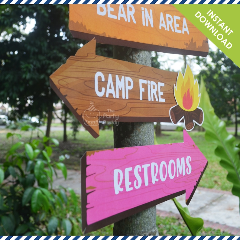 May include: Printable camping sign set with three wooden signs. The signs are brown with white text and point to the right. The top sign says "Bear in Area", the middle sign says "Camp Fire" with a small orange fire graphic, and the bottom sign says "Restrooms".