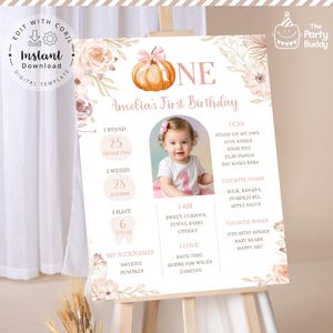 Op de afbeelding: Een gepersonaliseerd eerste verjaardagsbord met een pompoenillustratie en bloemaccenten. Het bord bevat de foto van het kind, de lengte (63,5 cm), het gewicht (12,7 kg) en favoriete dingen. De tekst luidt "Direct downloaden".