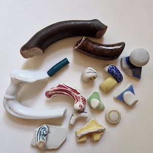 以下が含まれることがあります： 青、白、赤、黄、茶色など、さまざまな色と模様の壊れた陶磁器の断片の詰め合わせ。これらの断片は、ティーポットやその他の陶磁器のオブジェクトから来ている可能性があります。