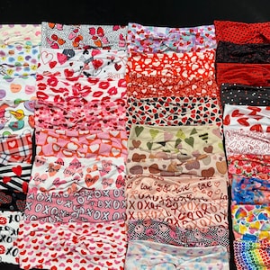 May include: A collection of 20 Valentine's Day themed headbands with various patterns, including hearts, lips, candy, and XOXO. The headbands are made of soft, stretchy fabric and are perfect for adding a touch of love to any outfit.
