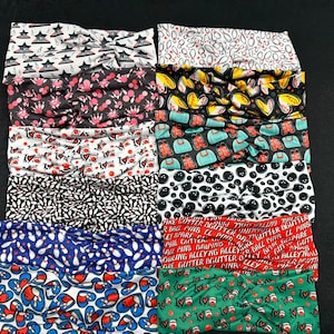 May include: A stack of ten colorful headbands with various bowling-themed patterns. The patterns include bowling pins, bowling balls, and the words "I love bowling".