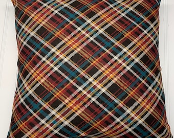 May include: A brown, red, yellow, and blue plaid throw pillow. The pillow is square shaped and has a soft, plush texture.