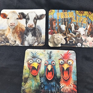 May include: Three different coasters featuring farm animals. The first coaster shows two calves, one brown and white and the other black and white. The second coaster shows a group of farm animals including a sheep, a pig, a horse, and a goat. The third coaster shows three chickens with their mouths open, one is blue, one is red, and one is green.