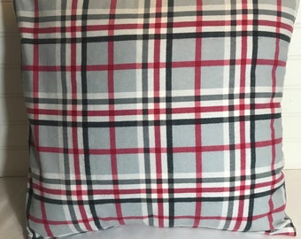 May include: A gray, red, white, and black plaid throw pillow. The pillow is made of a soft, comfortable fabric and has a square shape.