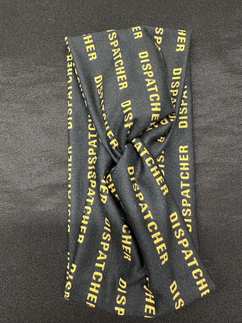 May include: Black headband with the words "Dispatcher" repeated in gold lettering.