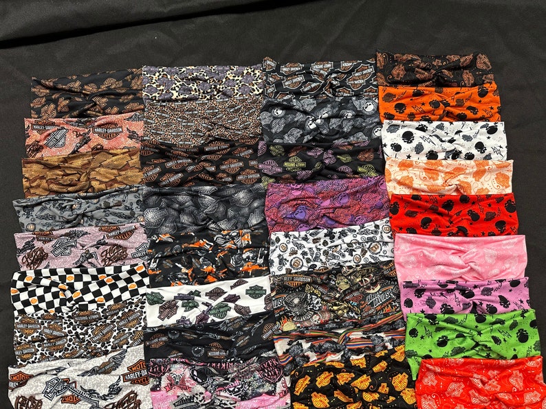 May include: A collection of 25 colorful headbands with various patterns, including Harley Davidson logos, skulls, and checkered designs. The headbands are made of a soft, stretchy fabric and are perfect for adding a touch of style to any outfit.