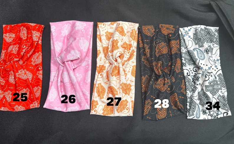 May include: Five different patterned headbands with the Harley Davidson logo. The headbands are in red, pink, white, black, and white with a paisley pattern. The headbands are numbered 25, 26, 27, 28, and 34.