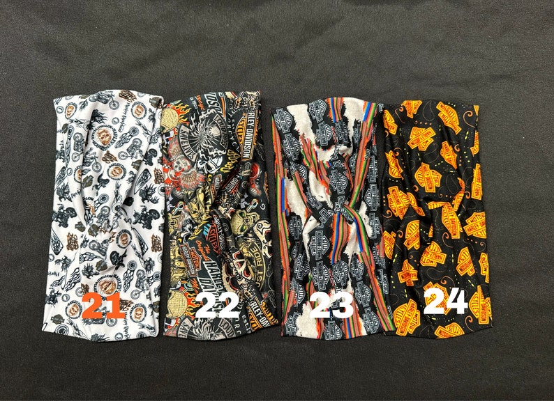 May include: Four different patterned headbands with a black, white, and orange color scheme. The headbands feature a Harley Davidson logo and other motorcycle-themed designs. The headbands are numbered 21, 22, 23, and 24.