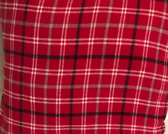 May include: Red, white, and black plaid throw pillow. The pillow is made of a soft, textured fabric.