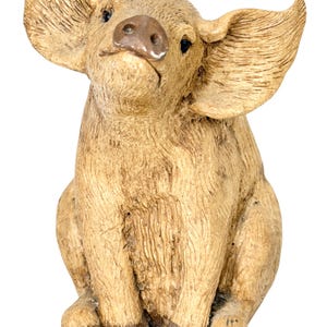 May include: A tan pig figurine with a textured, wood-like finish, featuring large, upright ears, a dark brown snout, and dark brown hooves. The pig is depicted in a seated position, looking upward with a neutral expression and detailed fur texture.