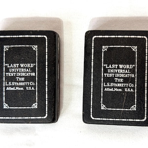 May include: A white ceramic mug with a black handle and the text "But First, Coffee" in a black, handwritten-style font. The mug is on a white surface.