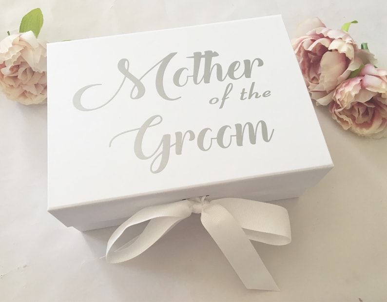 May include: White gift box with a silver ribbon and the text "Mother of the Groom" printed on the top.