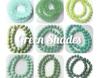 May include: Nine strands of round green glass beads in various shades of green, from light to dark. The beads are arranged in a grid pattern, with each strand labeled with a number from 1 to 9.