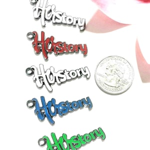 May include: Five metal charms shaped like the word History in cursive script, featuring white, red, white, blue, and green enamel fill. A US quarter coin is placed next to the charms for scale, showing the charms are approximately 1 inch wide.