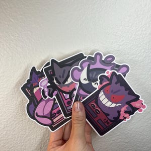 May include: A set of four stickers featuring the Pokemon Ghost-type, Gengar, in various poses. The stickers are printed on a clear vinyl with a glossy finish. The stickers are approximately 3 inches in size.