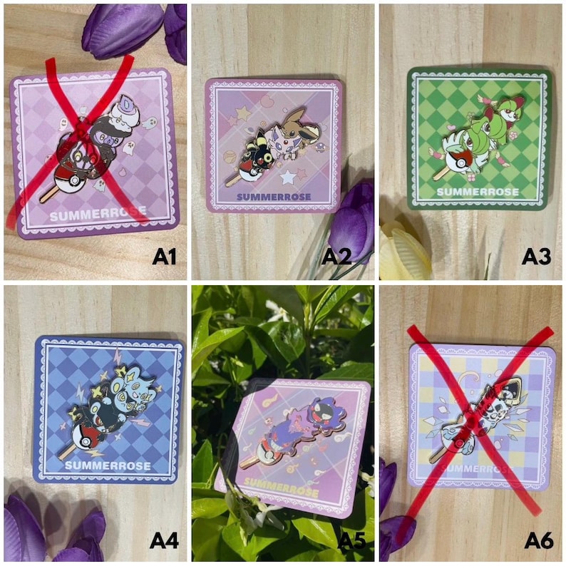 May include: A collection of six square backing cards featuring enamel pins shaped like dango skewers, each topped with various cartoon creatures. The cards display the text SUMMERROSE and feature checkered patterns in purple, green, and blue color schemes.