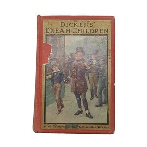 Pode incluir: Livro antigo intitulado "Dickens' Dream Children" com capa vermelha e letras douradas. A ilustração da capa retrata um homem e um menino caminhando em uma rua com outras figuras ao fundo. O livro está ligeiramente danificado.