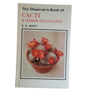 May include: A book titled "The Observer's Book of Cacti & Other Succulents" by S. H. Scott. The cover features a close-up photograph of a cactus with red flowers in a terracotta pot.
